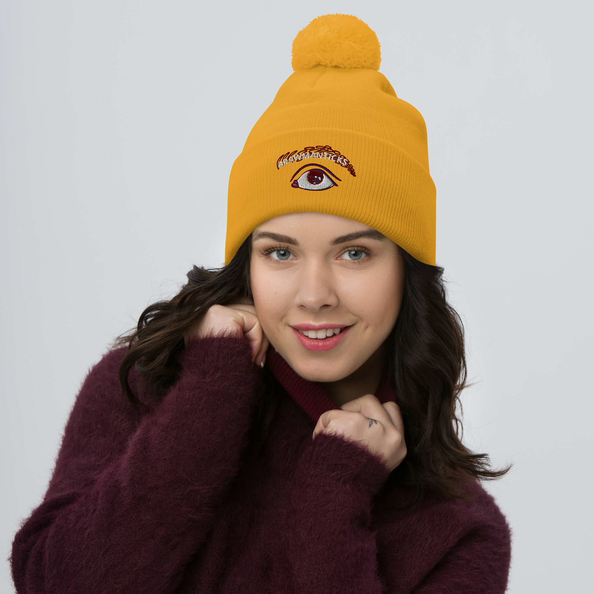 Female Model Wearing Gold Pom-Pom Beanie with Eye Embroidery - ARAWMANTICKS