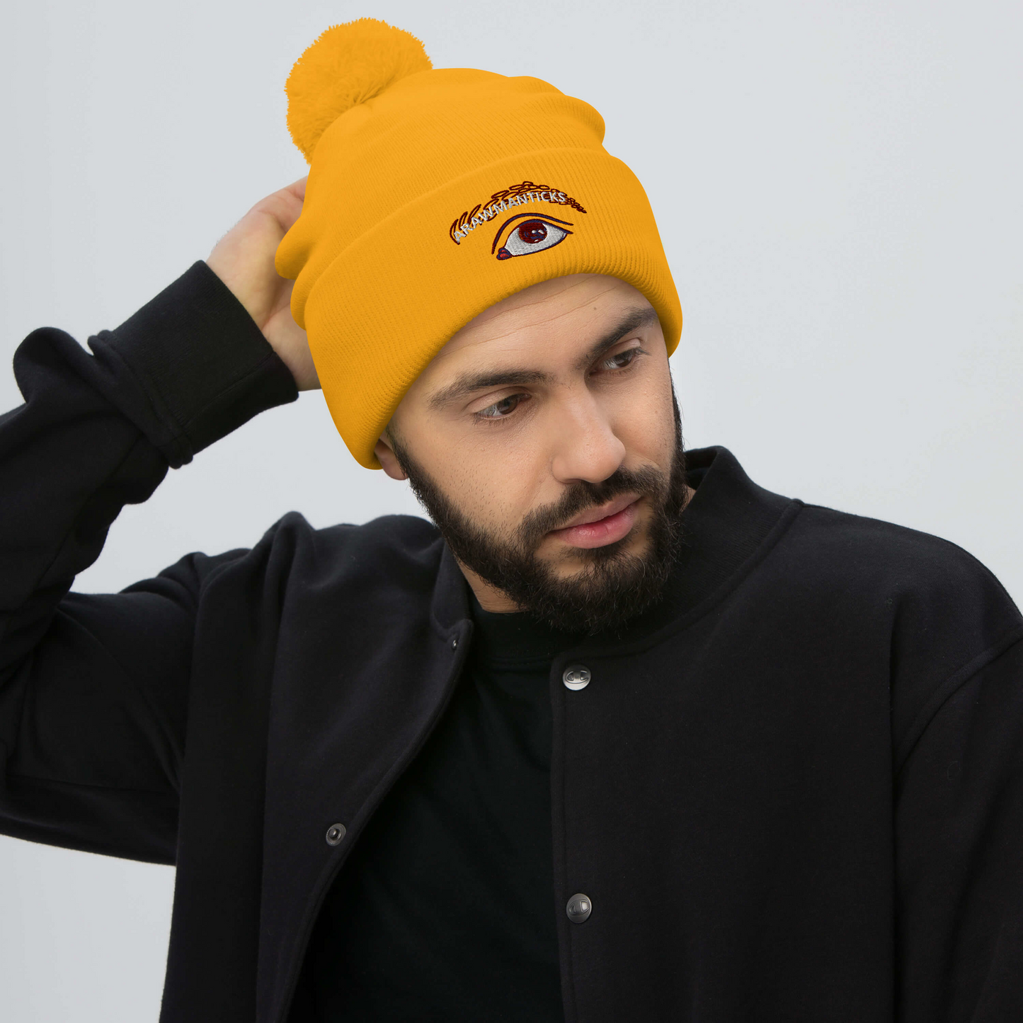 Male Model Wearing Gold Pom-Pom Beanie with Eye Embroidery - ARAWMANTICKS